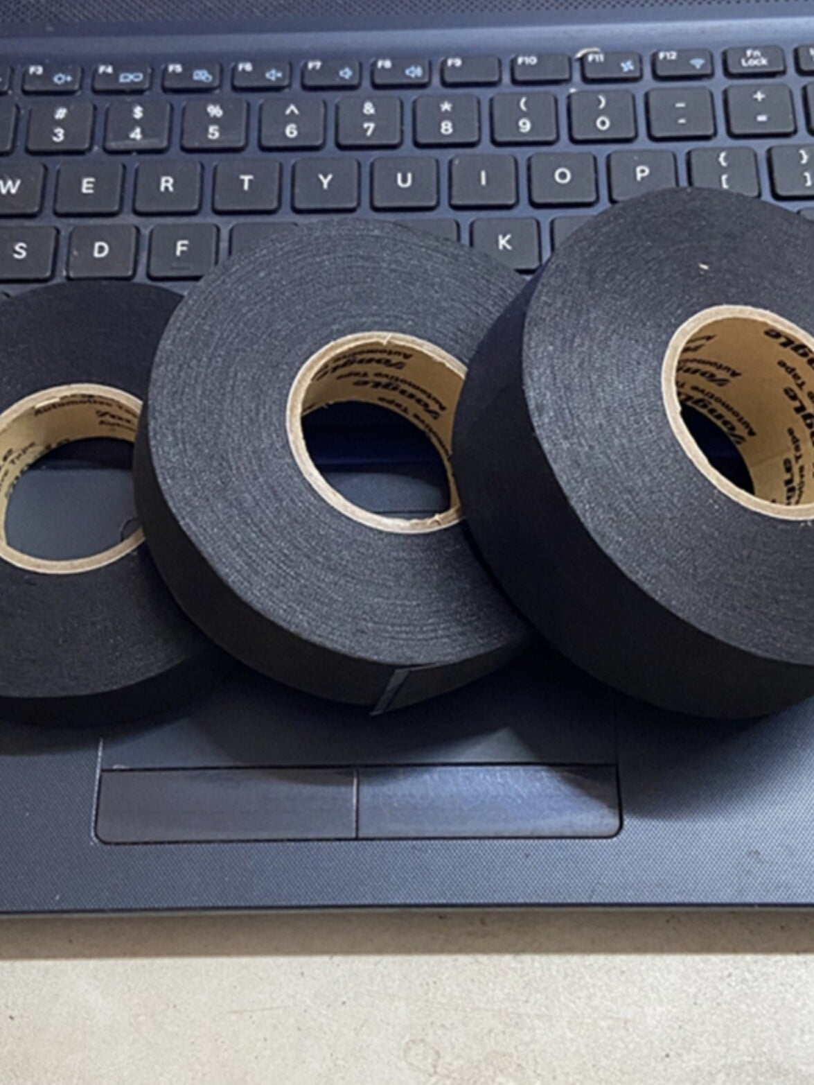 Avtomobil naqilləri üçün qoşqu polyester parça yüksək özlülük, yüksək temperatur müqaviməti və aşınmaya davamlı izolyasiya Kabin istifadəsi üçün qara rəngli gənc qara parça əsas elektrik lenti