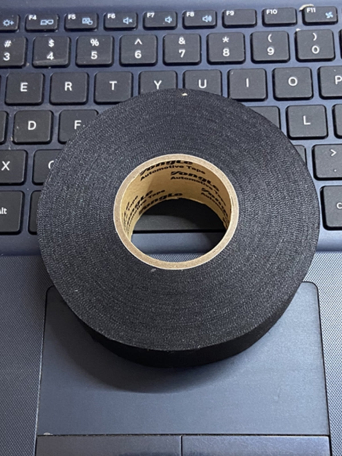 Avtomobil naqilləri üçün qoşqu polyester parça yüksək özlülük, yüksək temperatur müqaviməti və aşınmaya davamlı izolyasiya Kabin istifadəsi üçün qara rəngli gənc qara parça əsas elektrik lenti