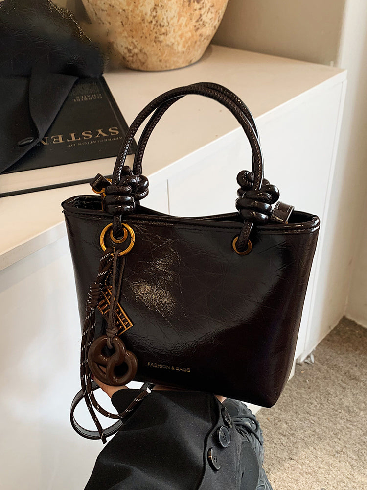 Yüksək səviyyəli, trenddə olan qadınlar üçün kiçik çanta, 2025-ci ilin yeni payız/qış üslubunda, vedrə çantası, sadə lüks, niş üslublu çarpaz bədən çantası.