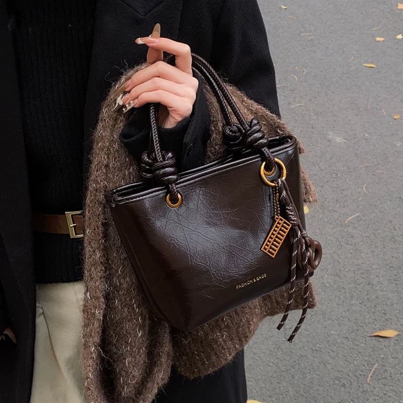 Yüksək səviyyəli, trenddə olan qadınlar üçün kiçik çanta, 2025-ci ilin yeni payız/qış üslubunda, vedrə çantası, sadə lüks, niş üslublu çarpaz bədən çantası.