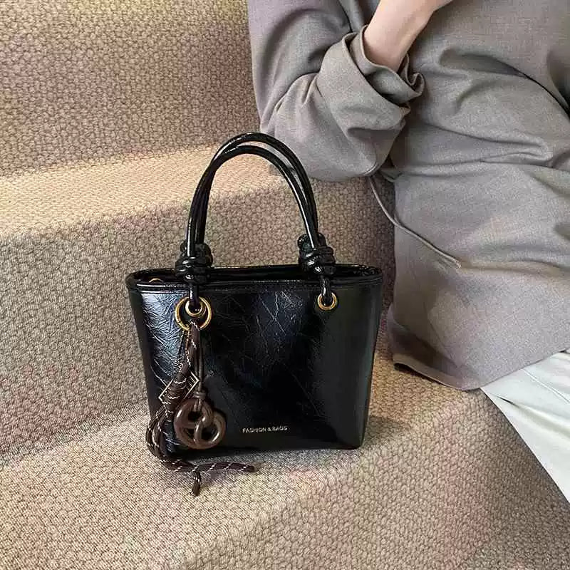 Yüksək səviyyəli, trenddə olan qadınlar üçün kiçik çanta, 2025-ci ilin yeni payız/qış üslubunda, vedrə çantası, sadə lüks, niş üslublu çarpaz bədən çantası.